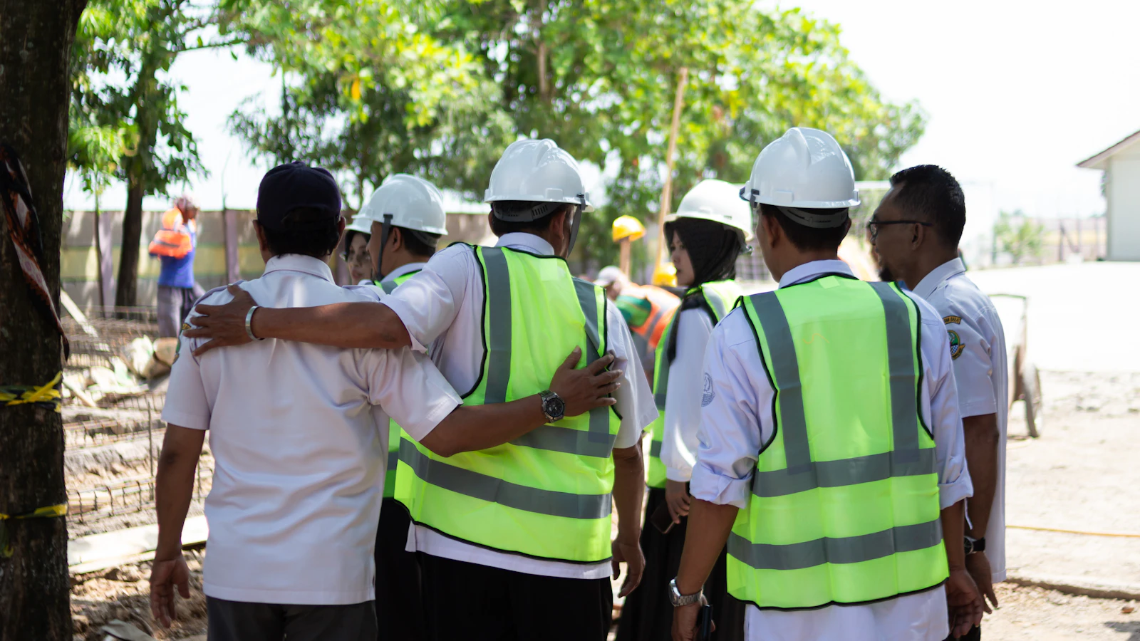 Construction and operations team in hard hats and vests reviewing project work together